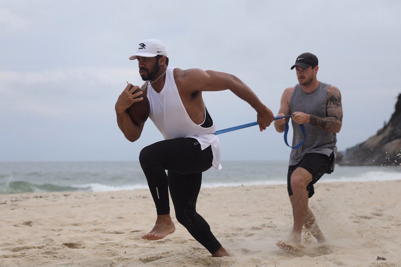Fase Preparatória - o atleta Russell Wilson treinando com seu personal na areia.